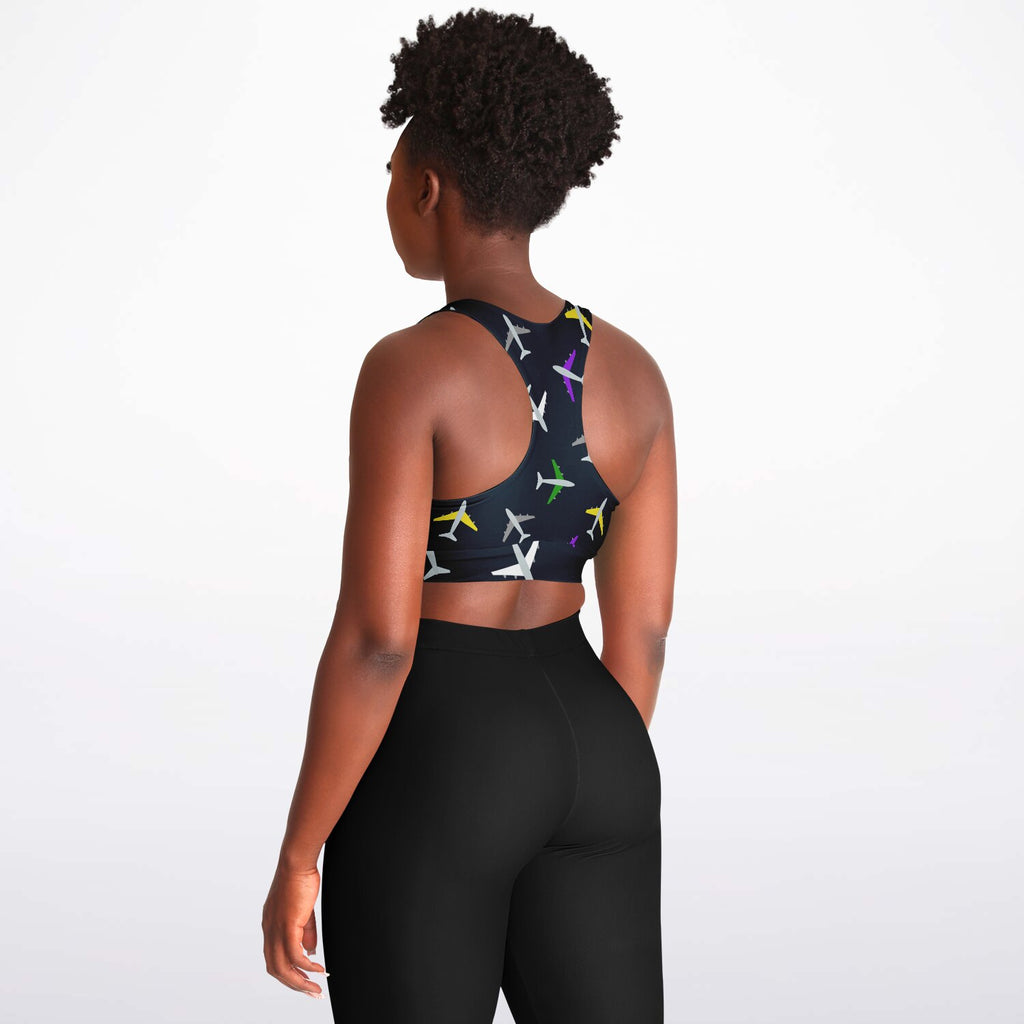 Left-side view of a woman wearing an airplane-patterned padded sports bra, highlighting the vibrant aviation-themed print and comfortable fit.